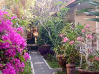 un jardín con flores rosas y plantas en Krisda Ubud Guest House, en Ubud