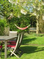 a picnic table with two chairs and a hammock in a park at La Quitapenas in Ronse