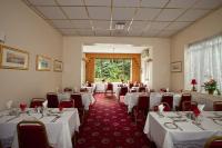 a room filled with tables and chairs with white table cloth at Laguna Hotel in Bournemouth