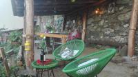 a patio with two green chairs and a table at Gîte La Fontaine Corse in Loreto-di-Casinca