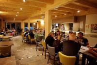 a group of people sitting at tables in a restaurant at Camping Bissen in Esch-sur-Sûre