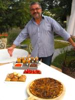 een man die voor een tafel met eten staat bij La Fréjade in Lisle-sur-Tarn