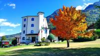 a red tree in front of a white building at Hotel Diana Jardin et Spa in Aosta