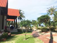 a house with a palm tree in the yard at Peppercorn Beach Resort in Phú Quốc