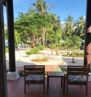 two chairs and a table with a view of a park at Peppercorn Beach Resort in Phú Quốc
