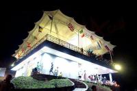 un edificio illuminato con persone che lo circondano di Bravo Adventure Glamping a Gunungmalang