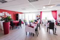 Un restaurante con mesas y sillas y paredes rojas. en Le Grand Jardin, en Aujargues