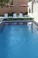 una piscina con sillas y sombrillas en un edificio en Almond Hotel Apartments, en Amán