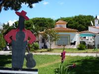 a statue of a chicken on a skateboard in front of a house at Xanadu Rural in Chiclana de la Frontera