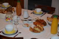 a table with plates of bread and cups and bottles of orange juice at Les Chênes Bleus in Sainte-Marie-de-Ré