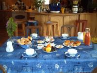 a table with a blue table cloth with food on it at Les Chênes Bleus in Sainte-Marie-de-Ré