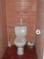 a bathroom with a toilet in a wooden wall at Les Chênes Bleus in Sainte-Marie-de-Ré