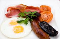 a plate of food with eggs sausage and tomatoes at Appleby Manor Hotel & Garden Spa in Appleby