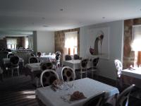 サン・ディエにあるLogis Hôtel Le Régal & Spaの白いテーブルと椅子のあるダイニングルーム