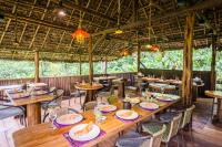 a dining room with wooden tables and chairs at Hakuna Matata Amazon Lodge in Archidona