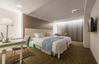 a hotel room with a bed and a desk at Forward Hotel Taipei Nangang in Taipei