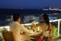 Un hombre y una mujer sentados en una mesa con copas de vino. en Hotel Boutique Milla de Plata, en Torreguadiaro