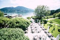 un grupo de mesas y sillas junto a una masa de agua en Hotel Terrassenhof, en Bad Wiessee