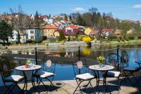 Un patio con mesas y sillas y una vista de una ciudad. en ROMANTIK HOTEL ELEONORA, en Tábor