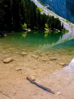 a body of green water with trees and a mountain at Altipik - Lodges Insolites in Mont-Saxonnex