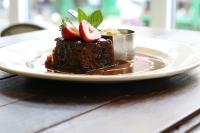 um pedaço de bolo de chocolate com morangos num prato em The Cawdor em Llandeilo