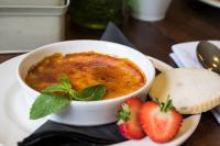 uma tigela de sopa com morangos num prato em The Cawdor em Llandeilo