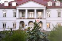 a white house with a rose in front of it at Bistrampolis Manor in Kučiai