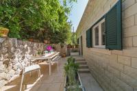 eine Terrasse mit einem Tisch und Stühlen neben einer Steinmauer in der Unterkunft I Sassi Bianchi - East Villa in Cavtat