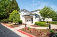 Un edificio blanco con flores delante. en Studio 6-Duluth, GA - Atlanta - Gwinnett Place, en Duluth