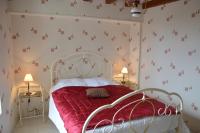 a bedroom with a bed with a red bedspread at Aux Jardin&#39;s de la Bosniere in Cussay
