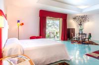 a bedroom with a large white bed and a table at Hotel Poseidon in Positano