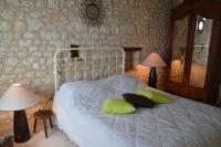 a bedroom with a bed with green pillows and a mirror at Aux Jardin&#39;s de la Bosniere in Cussay