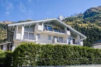 a large white building with bushes in front of it at Litchi Apartment in Chamonix