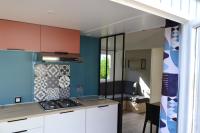 a kitchen with white cabinets and a blue wall at Village Océanique in Le Bois-Plage-en-Ré