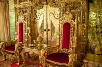 un trono de oro en una habitación con sillas rojas en Nakaraj Princess Chiang Rai - Walking Street, en Chiang Rai