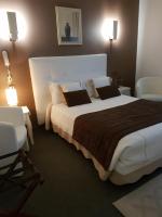 Un dormitorio con una cama grande y dos sillas. en Hotel Christina, en Châteauroux