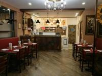 a dining room with tables and chairs and a kitchen at Residence Eleonora in Sottomarina