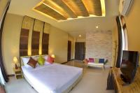 a bedroom with a large bed and a tv at Palm Leaf Resort Koh Tao in Ko Tao