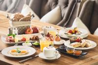 a table topped with plates of breakfast foods and drinks at Living & Spa Vitalhotel Edelweiss in Neustift im Stubaital