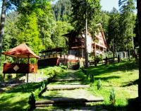 una casa en medio de un campo de hierba con un edificio en Complex Balea, en Cumpăna