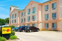 Un edificio con coches aparcados en un estacionamiento. en Super 8 by Wyndham Irving&#47;DFW Apt&#47;North, en Irving