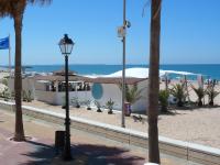 a street light next to a beach with palm trees at Macavi in Rota