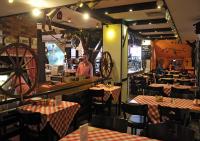a restaurant with tables and chairs and people in the restaurant at Hotel Edel Weiss in Bremen