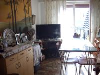 a living room with a television and a table and chairs at Anna in front of the sea Apartment in Sitia