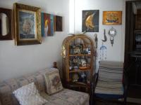 a living room with a couch and a shelf of items at Anna in front of the sea Apartment in Sitia
