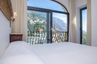 a bedroom with a bed and a large window at Hotel Poseidon in Positano