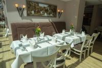 Un comedor con mesas y sillas blancas. en Walpurgishof, en Hahnenklee-Bockswiese