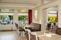 Un comedor con mesas y sillas y ventanas. en Walpurgishof, en Hahnenklee-Bockswiese