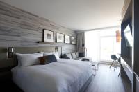 a bedroom with a large bed and a large window at Entourage sur-le-Lac in Lac-Beauport