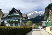 une maison dans une rue avec une montagne en arrière-plan dans l&#39;établissement Apartment Haus Wieser, à Gröbming